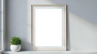 Empty wooden frame mockup on white shelf with green plant in modern minimalist interior for artwork display and home decor presentation.