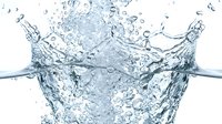 Clear water splash with ice cubes creating dynamic crown-shaped formation against white background. Fresh beverage concept for summer drinks and cooling refreshment.