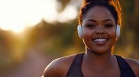 Happy African American woman wearing white headphones smiling during outdoor workout at golden hour sunset for fitness and wellness lifestyle content.