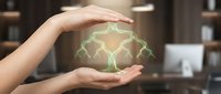 Hands protecting glowing green brain with neural network connections symbolizing mental health care, cognitive protection and neurological wellness concepts.