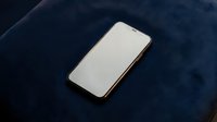 Smartphone with blank white screen on dark blue fabric surface, ready for app mockup or user interface design projects.