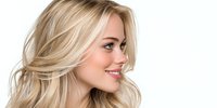 Young blonde woman with wavy hair smiling in profile view against white background for beauty and hair care advertising campaigns.