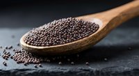 Organic chia seeds in wooden spoon on dark slate surface for healthy cooking and superfood nutrition concepts.