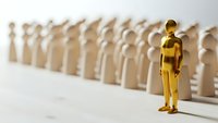 Golden figure standing out from crowd of white figures representing leadership, uniqueness, and individual success in business and personal development.