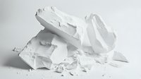 Crumpled white paper pieces scattered on white surface creating minimalist composition with soft shadows and textures. Clean artistic arrangement.