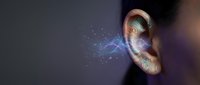 Human ear with colorful sound waves and particles emanating from ear canal on dark background. Concept for hearing, audio technology, music perception.