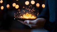 Magical glowing golden sparkles floating above an open palm against dark background with bokeh lights, creating mystical and enchanting atmosphere.