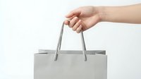 Hand holding gray shopping bag handle on white background for retail and consumer purchase concepts.