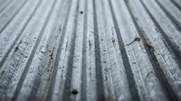 Weathered wooden deck planks with peeling white paint showing natural wood grain texture beneath, creating rustic surface for backgrounds and design projects.