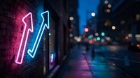 Neon arrows glowing pink and blue on brick wall at night with blurred city street lights in background for business growth and direction concepts.