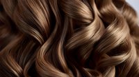 Luxurious wavy brown hair with blonde highlights close-up showing professional styling and healthy shine. Soft curls create elegant texture pattern for beauty and haircare industry.