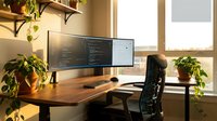 Modern home office workspace with dual monitor setup, wooden desk, ergonomic chair and green plants creating productive work environment for programming and coding.