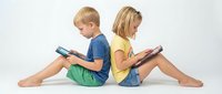 Two children sitting back to back reading books on white background, boy and girl engaged in educational activity for learning concepts.