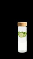 Glass infuser water bottle with cucumber slices and mint, wooden bamboo lid, isolated on transparent background, ready for health, wellness, and eco product designs.