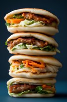 Stack of four gourmet sausage sandwiches with fresh vegetables and condiments on soft buns against dark background for food photography and menu design.