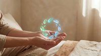 Close-up of hands holding glowing holographic sphere with leaf particles, representing sustainability, technology, and environmental innovation for eco-friendly business concepts.