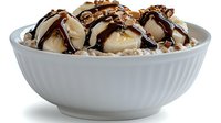 Vanilla ice cream scoops topped with chocolate sauce and nuts served in a white ceramic bowl, suitable for dessert menus and food advertising.