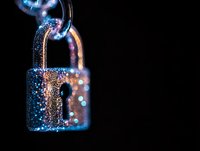 Glowing padlock with blue sparkles and bokeh effects on dark background, dramatic lighting creates mystical atmosphere for security and protection concepts.