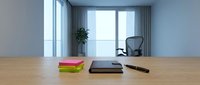 Wooden desk with colorful sticky notes, tablet, and pen in bright modern office with large windows, mesh chair, and potted plant for workspace and productivity concepts.