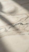 Elegant marble surface with natural veining patterns and soft shadow overlay creating luxurious texture for premium design projects and sophisticated branding.