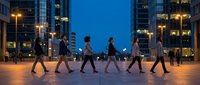 Business professionals walking in formation across urban plaza at twilight with illuminated office buildings creating dynamic corporate teamwork scene.