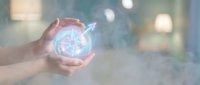 Hands protecting glowing compass with arrow pointing direction in blurred office background symbolizing guidance navigation and business strategy planning.