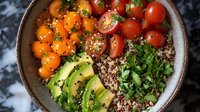 Fresh quinoa bowl with sliced avocado, cherry tomatoes, and herbs served in ceramic bowl on dark background, healthy vegetarian meal for clean eating.