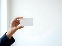 Hand holding blank white business card isolated on white background, suitable for corporate branding, identity design, and professional marketing materials.