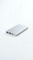 Silver portable power bank with multiple USB ports isolated on white background for electronic device charging and mobile accessories.