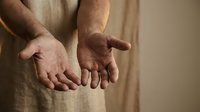 Open hands of Jesus Christ showing nail wounds from crucifixion, palms extended forward in gesture of offering and sacrifice, religious spiritual concept.