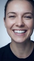 Close-up portrait of happy young Caucasian woman with genuine smile showing white teeth, natural skin texture and joyful expression for wellness concepts.