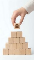 Hand placing wooden block with paw print on pyramid stack representing pet care services and animal welfare business growth concepts.