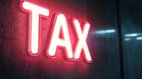 Glowing red neon TAX sign on dark wall with dramatic lighting effect creates urgent financial atmosphere for business and accounting concepts.