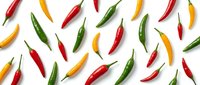 Colorful hot chili peppers pattern on white background. Fresh spicy vegetables in red, yellow and green colors isolated for cooking design.
