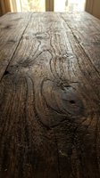 Rustic weathered wooden table surface with natural grain patterns and knots in warm sunlight for product display and food photography backgrounds.