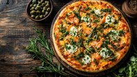 Fresh baked pizza with melted mozzarella, tomato sauce and aromatic herbs on rustic wooden background with olives and rosemary sprigs.