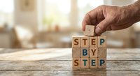 Senior hand placing wooden letter blocks spelling step by step on table, business planning and goal achievement concept for presentations and training.