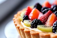 Fresh fruit tart with strawberries, blackberries and kiwi slices on pastry crust, close-up dessert photography for bakery menu and culinary advertising.