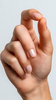 Close-up of Caucasian female hand with natural manicure against white background, demonstrating elegant finger position for beauty and nail care concepts.