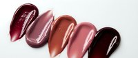 Glossy lipstick swatches in burgundy, pink, coral, nude and dark berry shades on white background for cosmetic beauty and makeup applications.