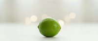 Fresh green lime with water droplets isolated on white background, suitable for food and beverage design projects.