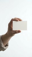 Male hand holding blank white business card against neutral background. Isolated on white for branding, corporate identity and marketing mockup designs.