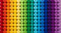 Colorful rainbow gradient of round craft beads arranged in organized rows from red to purple, perfect for jewelry making and creative projects.
