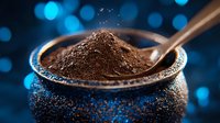 Ground coffee powder in silver spoon on dark background with blue bokeh lights, macro food photography showing texture and aroma of fresh coffee.