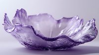 Artistic purple glass bowl with organic wavy edges and textured surface creates ethereal lighting effect against soft background.