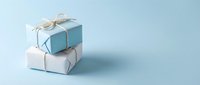 Two elegant gift boxes with natural twine bows stacked on soft blue background for special occasions and celebrations.