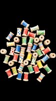 Colorful wooden spools with patterned thread in red, blue, green, and yellow isolated on transparent background, ready for clipart, t-shirt design, stickers, and print-on-demand products.