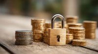 Wooden padlock with stacks of gold coins on rustic wooden surface, symbolizing financial security and wealth protection.