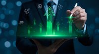 Businessman holding tablet with glowing green arrows and digital icons, symbolizing business growth, financial success, and technology innovation.
