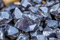 Raw dark gray silicon crystals with sharp edges and metallic luster in macro photography, showing natural geometric patterns and mineral structure. Suitable for industrial backgrounds.